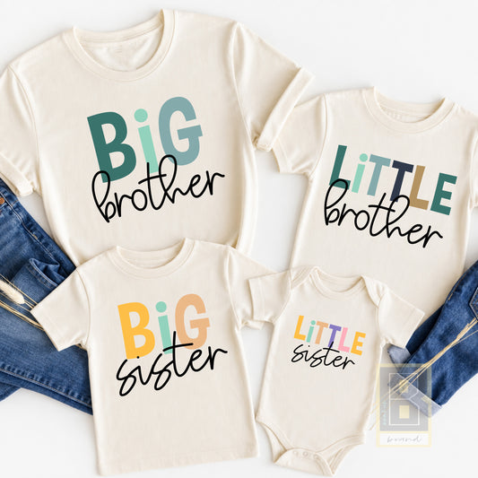 Toddler boy wearing a cream Big Brother shirt with colorful block-letter graphic, matching Little Brother baby bodysuit